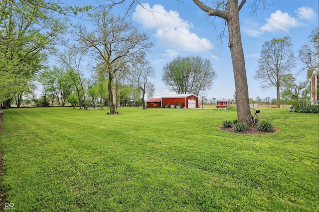 view of yard featuring an outdoor structure, an outbuilding, and a detached garage