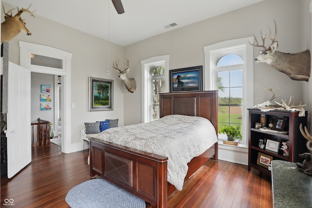 bedroom featuring dark wood finished floors, visible vents, and a ceiling fan