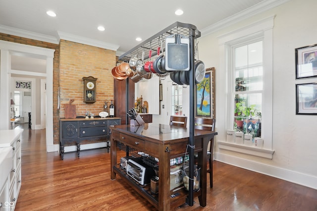 dining room featuring ornamental molding, baseboards, and wood finished floors