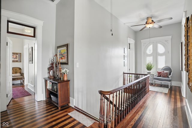 foyer entrance with dark wood finished floors, baseboards, and ceiling fan