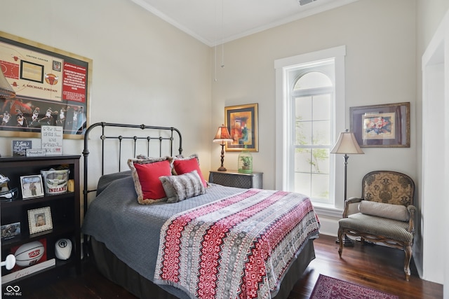 bedroom with ornamental molding, visible vents, and wood finished floors