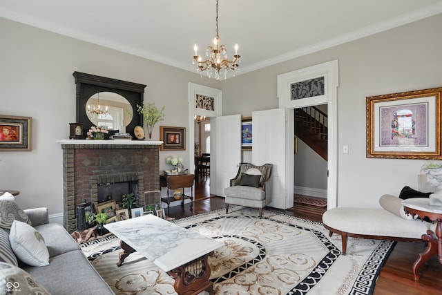 living room featuring ornamental molding, a brick fireplace, a chandelier, wood finished floors, and stairway