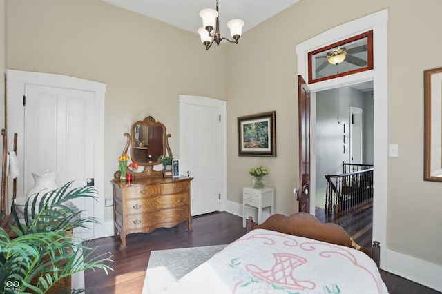 bedroom featuring a notable chandelier, baseboards, and wood finished floors