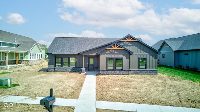 714 Cypress Dr, Tipton, IN 46072 - view of front of home featuring board and batten siding, roof with shingles, a sunroom, and stone siding