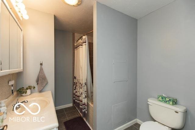 5973 Masten Rd, Coatesville, IN 46121 - full bathroom with baseboards, toilet, shower / tub combo with curtain, vanity, and tile patterned flooring