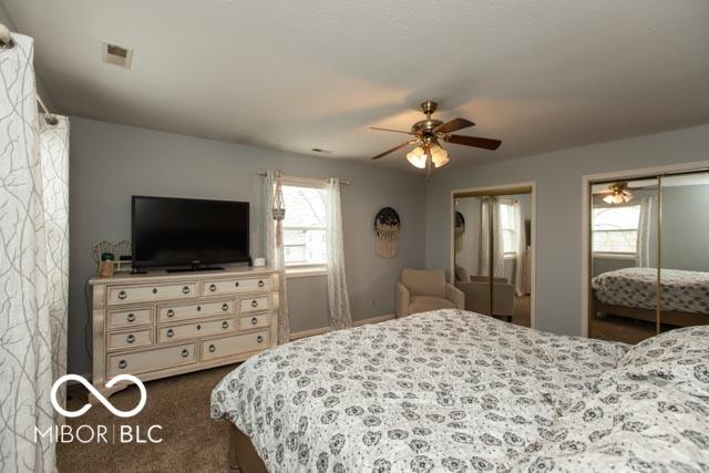 5973 Masten Rd, Coatesville, IN 46121 - bedroom with dark carpet, visible vents, ceiling fan, and two closets