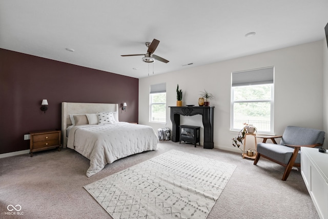 1024 Cyprian Way, Lebanon, IN 46052 - bedroom with light colored carpet, a ceiling fan, baseboards, and a wood stove