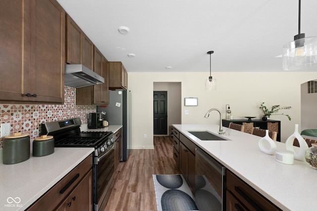 1024 Cyprian Way, Lebanon, IN 46052 - kitchen with appliances with stainless steel finishes, a sink, under cabinet range hood, dark wood-style flooring, and light countertops