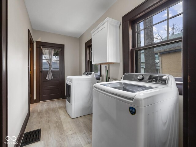 270 W Broadway St, Shelbyville, IN 46176 - clothes washing area featuring baseboards, washing machine and clothes dryer, visible vents, light wood-style flooring, and cabinet space