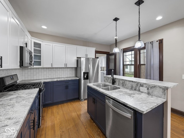 270 W Broadway St, Shelbyville, IN 46176 - kitchen featuring a sink, backsplash, white cabinetry, light wood-type flooring, and stainless steel appliances