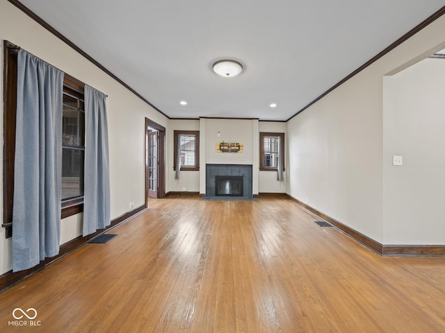 270 W Broadway St, Shelbyville, IN 46176 - unfurnished living room with visible vents, a tile fireplace, baseboards, ornamental molding, and wood-type flooring