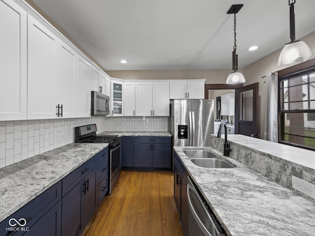 270 W Broadway St, Shelbyville, IN 46176 - kitchen featuring white cabinetry, tasteful backsplash, stainless steel appliances, hanging light fixtures, and a sink