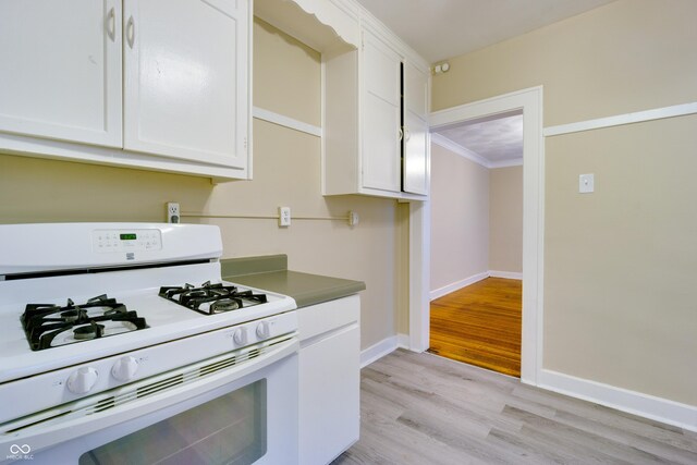 3619 Salem St, Indianapolis, IN 46208 - kitchen featuring crown molding, gas range gas stove, baseboards, white cabinets, and light wood-style floors