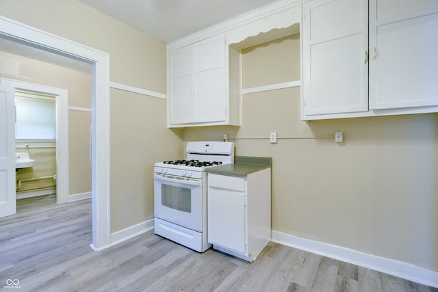3619 Salem St, Indianapolis, IN 46208 - kitchen featuring baseboards, white cabinetry, light wood-style flooring, and white range with gas cooktop
