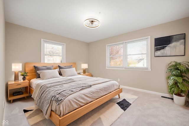 bedroom featuring baseboards and light colored carpet