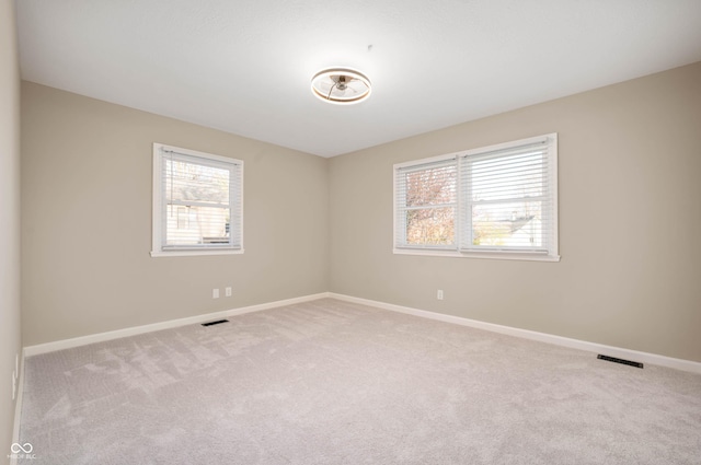 carpeted empty room with baseboards and visible vents