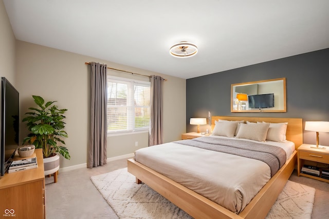 bedroom with light carpet and baseboards