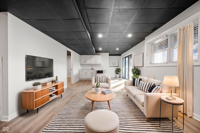 living area with recessed lighting, visible vents, baseboards, and light wood-style flooring
