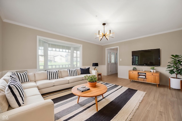 living room featuring crown molding, a notable chandelier, and light wood-style floors