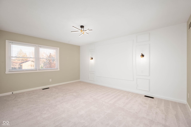 empty room with visible vents, light colored carpet, and baseboards