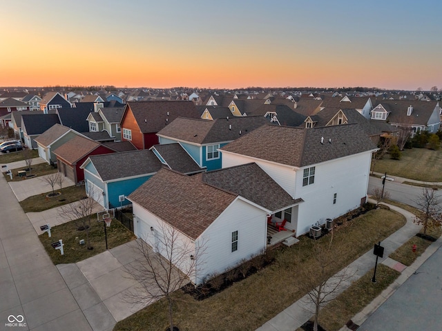 aerial view at dusk featuring a residential view