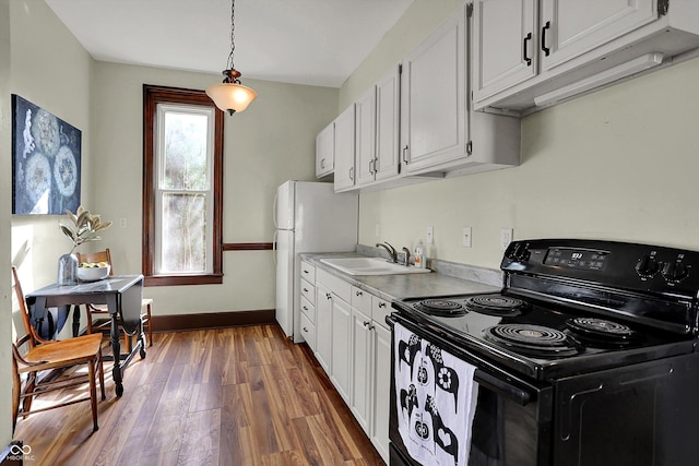 1157 Division St, Noblesville, IN 46060 - kitchen featuring electric range, light countertops, dark wood-style floors, white cabinetry, and freestanding refrigerator