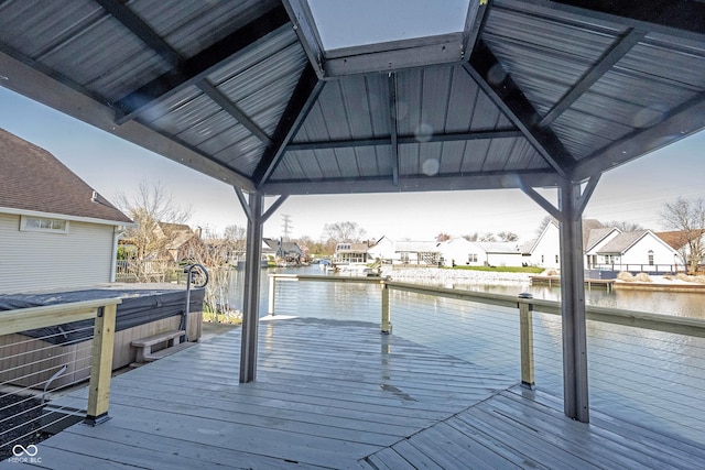 view of dock featuring a gazebo, a residential view, and a deck with water view
