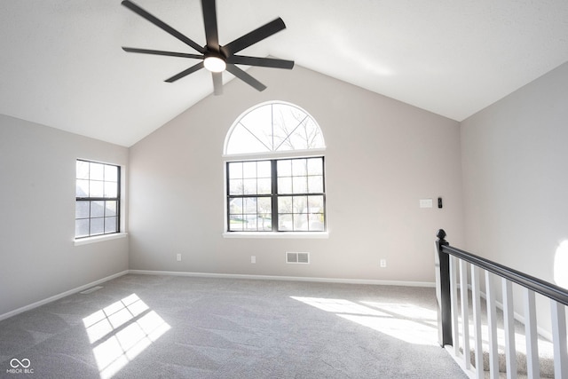 empty room featuring baseboards, vaulted ceiling, carpet floors, visible vents, and ceiling fan