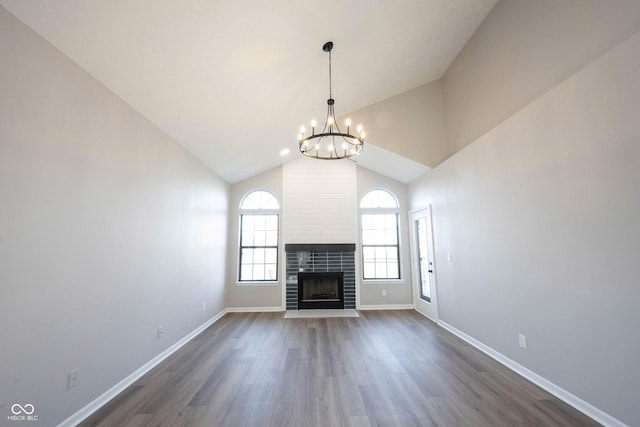 unfurnished living room with baseboards, a chandelier, a tile fireplace, and dark wood-style floors