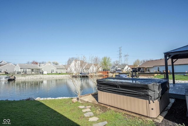 dock area with a residential view, a hot tub, and a water view