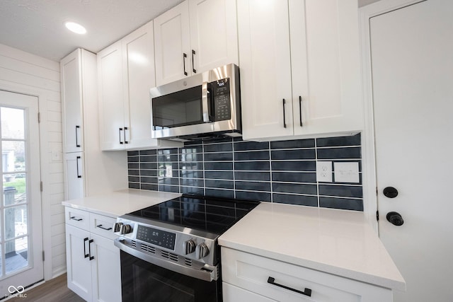 kitchen featuring dark wood-style flooring, light countertops, white cabinetry, backsplash, and stainless steel appliances
