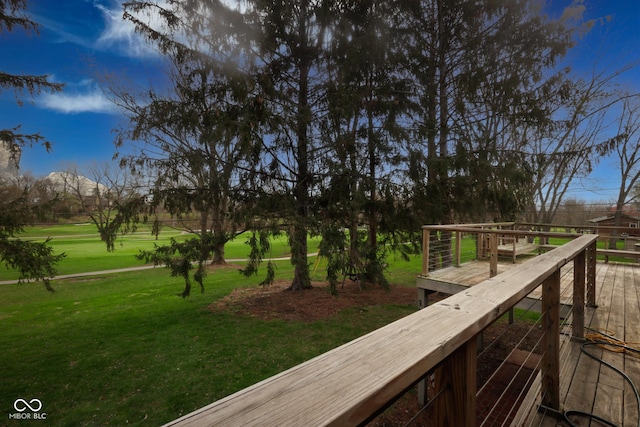 wooden terrace featuring a lawn