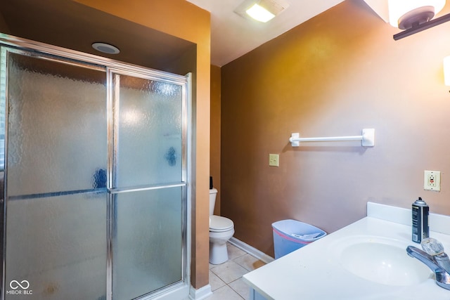 bathroom featuring tile patterned flooring, vanity, toilet, and a stall shower