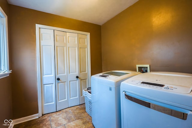 washroom with baseboards, laundry area, and washer and clothes dryer