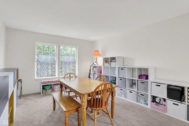 dining room featuring carpet, a desk, and baseboards