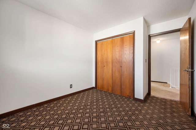 2804 Paso Del Norte Dr, Indianapolis, IN 46227 - unfurnished bedroom with baseboards, a closet, and dark carpet