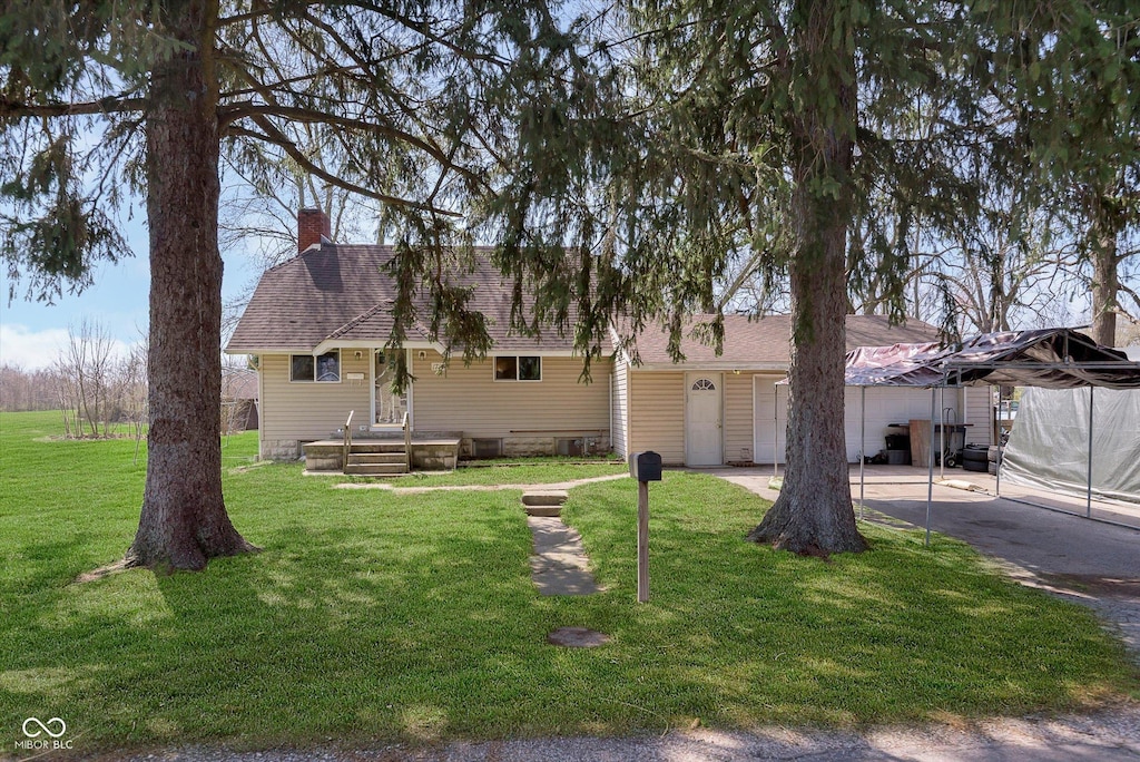 1714 E 34th St E, Marion, IN 46953 - ranch-style home with a front yard, a chimney, a shingled roof, and a patio area
