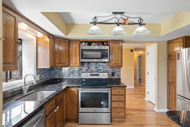 745 W Banta Rd, Indianapolis, IN 46217 - kitchen with brown cabinetry, a sink, backsplash, and stainless steel appliances