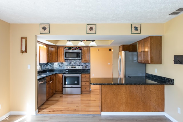 745 W Banta Rd, Indianapolis, IN 46217 - kitchen featuring brown cabinets, visible vents, a peninsula, and stainless steel appliances