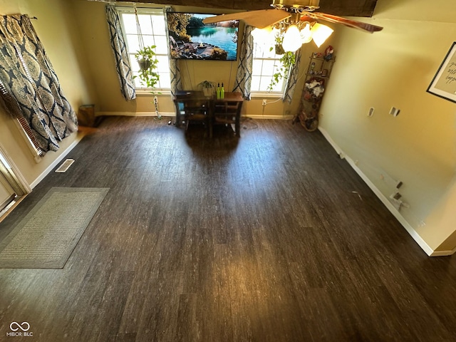 unfurnished dining area with baseboards, visible vents, plenty of natural light, and wood finished floors