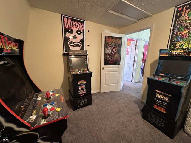 rec room featuring attic access, a textured ceiling, and carpet flooring