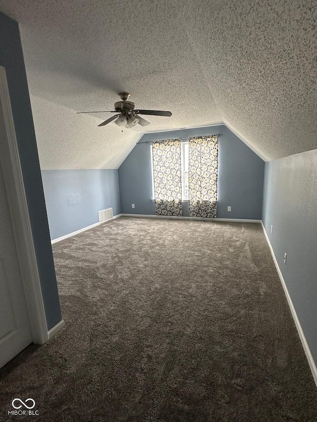 1071 Hazelwood Dr, Greenwood, IN 46143 - additional living space featuring vaulted ceiling, a textured ceiling, a ceiling fan, visible vents, and carpet