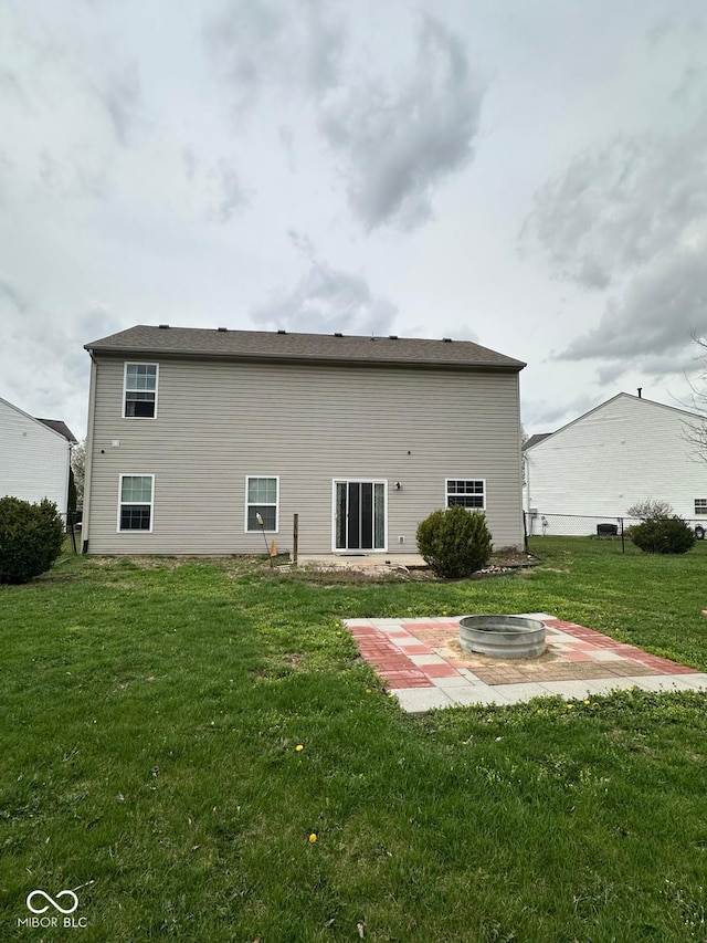 1071 Hazelwood Dr, Greenwood, IN 46143 - back of property with an outdoor fire pit, a patio area, and a lawn