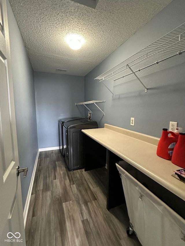 1071 Hazelwood Dr, Greenwood, IN 46143 - laundry area with laundry area, dark wood-type flooring, a textured ceiling, baseboards, and washer and clothes dryer