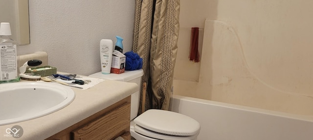 bathroom featuring a textured wall, shower / tub combo with curtain, toilet, and vanity