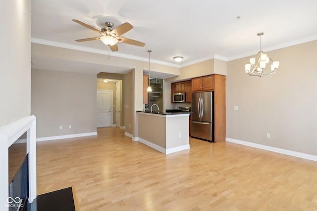 kitchen with open floor plan, dark countertops, brown cabinetry, and stainless steel appliances