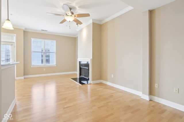unfurnished living room with light wood finished floors, a fireplace, ornamental molding, and a ceiling fan