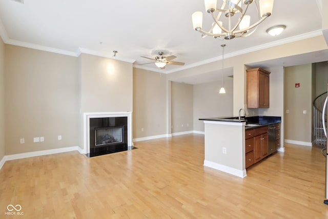 kitchen featuring dishwasher, dark countertops, a sink, ceiling fan with notable chandelier, and brown cabinetry