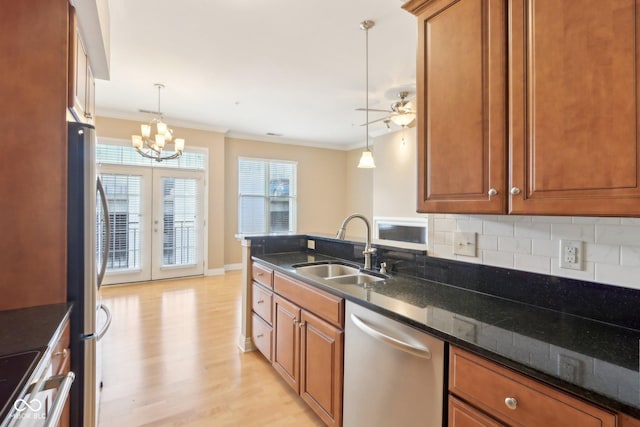 kitchen with a sink, crown molding, brown cabinets, and appliances with stainless steel finishes