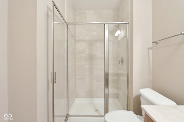 bathroom featuring a shower stall, toilet, and vanity